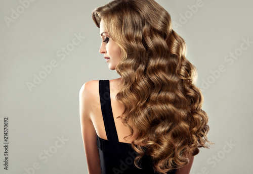 Foto Brunette brown girl with long  and   shiny curly hair
