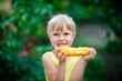© smile35 - The cheerful girl eats corn on a farm.