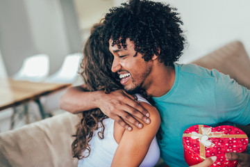 Wall Mural - Man giving a surprise gift to woman at home