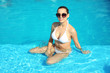© New Africa - Beautiful young woman wearing bikini in blue swimming pool