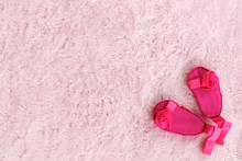 Pair Of Dark Pink Baby Girl Sandals Against Light Pink Background.