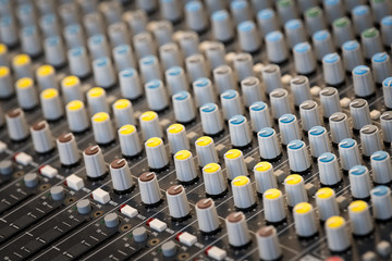 A sound mixing panel with various knobs