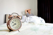 © Media  - Clock in the room background man lying on the bed with pain, sleep insomnia, blurred. Health care concept.