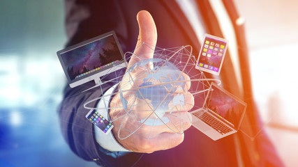 businessman holding a computer and devices displayed on a futuristic interface with international ne