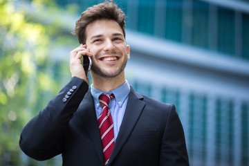 Young manager on the phone outdoor in an urban setting