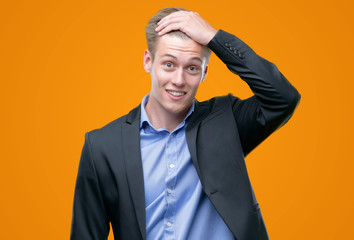 Wall Mural - Young handsome blond business man stressed with hand on head, shocked with shame and surprise face, angry and frustrated. Fear and upset for mistake.