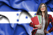 Happy female student holdimg books against national flag of Honduras