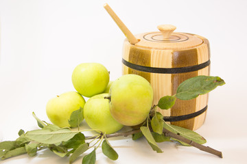 Wooden can with honey, green apples and leafs. (White background)