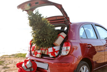 Red Car With Gift Boxes And Christmas Tree On Beach. Santa Claus Delivery