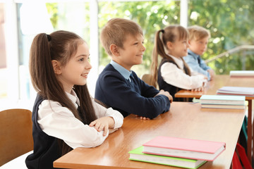 Little children in classroom. Stylish school uniform