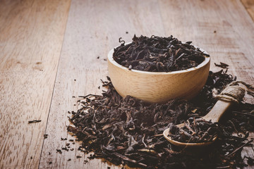 close-up of dry chinese tea in woonden bowl, vintage tone, selective focus