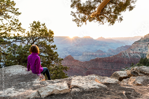 Fotografija  Tourist Is Seating On The Edge of Cliff and Watching of Sunrise at Grand Canyon