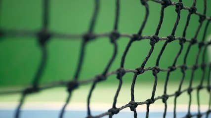 Close up of tennis equipment on the court. Sport, recreation concept. Yellow tennis balls hit the net on a clay green blue court next to the white line with copy space and soft focus