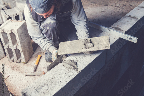 Fotomural Real construction worker bricklaying the wall using tools.