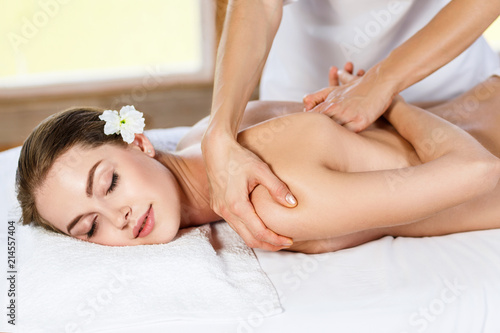 Beautiful woman lying on massage table and enjoying massage. Fototapet