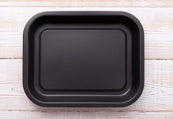 Wall Mural - Empty baking tray for pizza close up on wooden background top view horizontally. Mock up for design