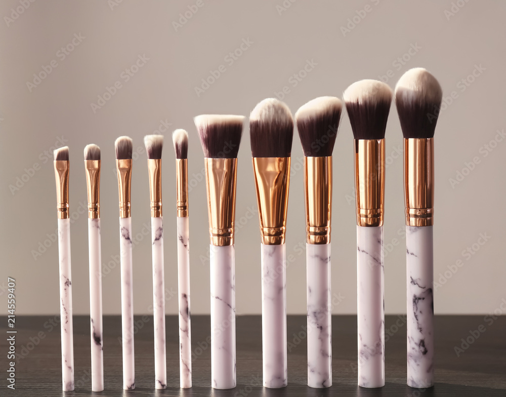 Makeup brushes for applying decorative cosmetics on wooden table