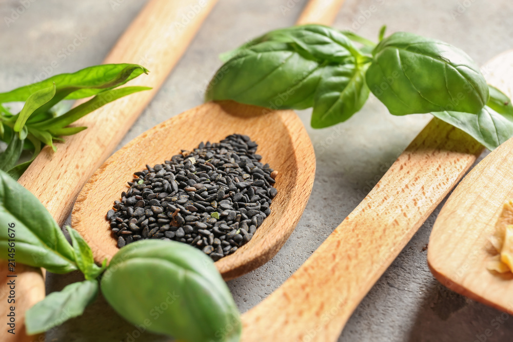 Wooden spoon with black sesame seeds on table