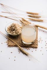 Canvas Print - Barley water in glass with raw and cooked pearl barley wheat/seeds. selective focus