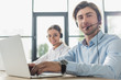 © LIGHTFIELD STUDIOS - male and female call center managers working together at modern office and looking at camera