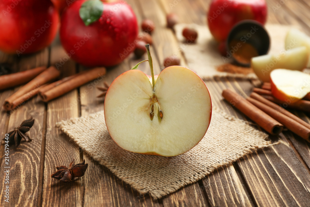 Half of fresh ripe apple and cinnamon on wooden table