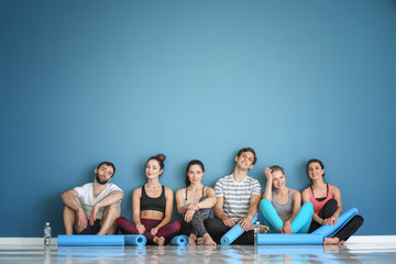 Sticker - Group of people with yoga mats sitting on floor near color wall