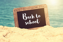 Back To School Written On A Vintage Chalkboard In The Sand Of A Beach