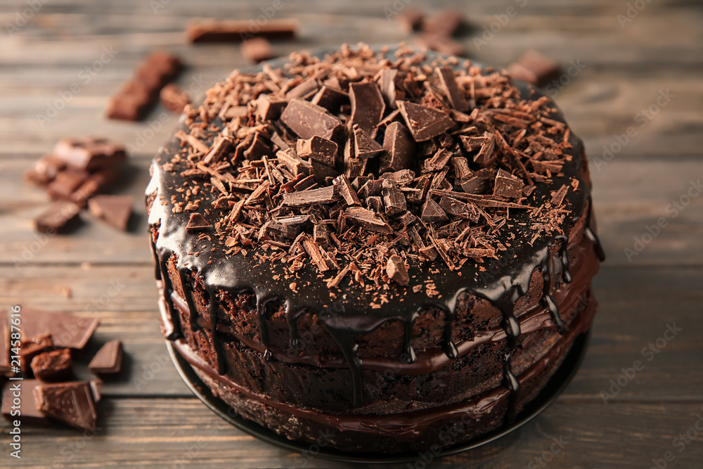 Plate with delicious chocolate cake on wooden table
