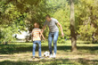 © Pixel-Shot - Happy father and son playing football in park