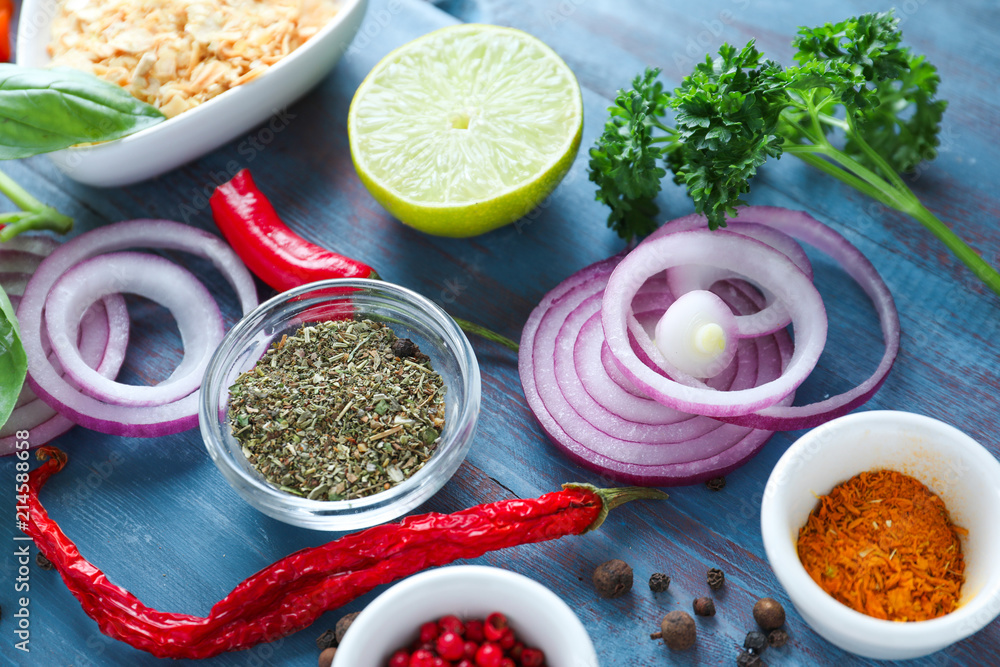 Various spices with vegetables on wooden background