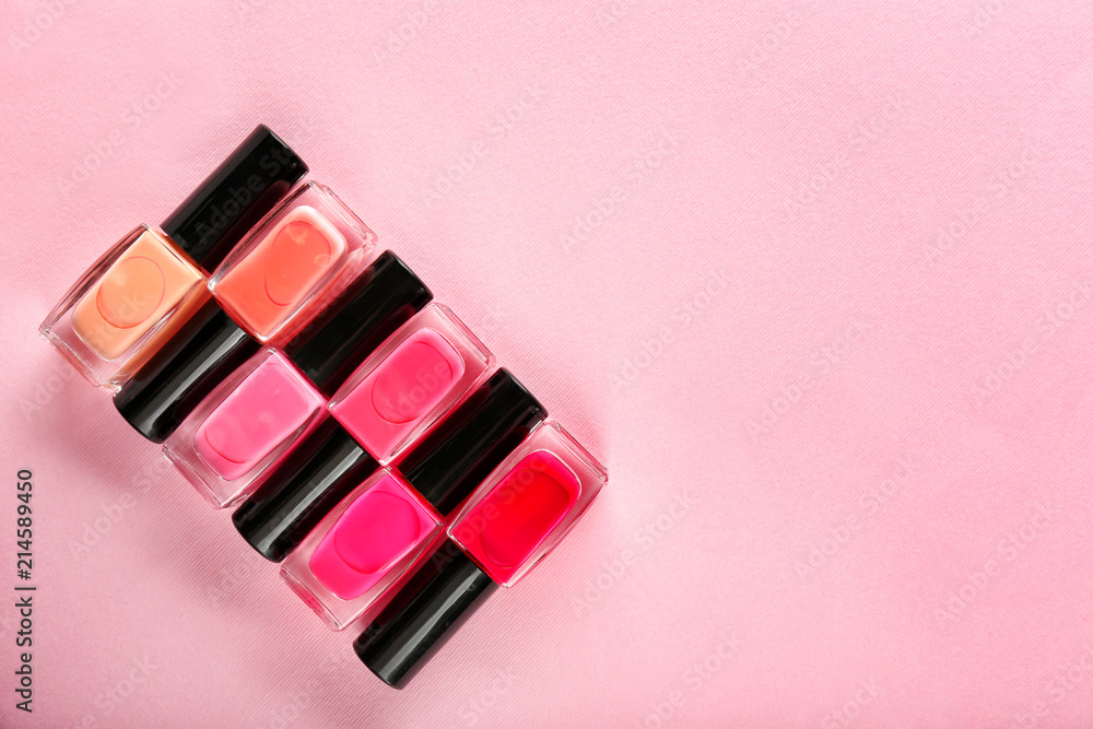 Bottles of nail polishes on color background