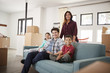 © Monkey Business - Portrait Of Happy Family Resting On Sofa Surrounded By Boxes In New Home On Moving Day