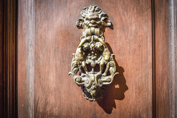 old metal knocker of a wooden door