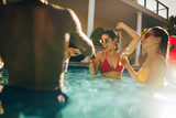 Fototapeta  - Happy friends making party inside pool
