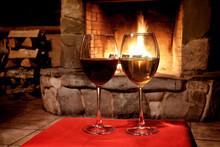 Chimney Place Wine Party Concept. Two Glasses Of Red White Wine, Fireplace Background. Romantic Xmas Postcard, Cozy Interior Of A Xmas Evening.