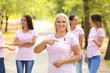 © Pixel-Shot - Beautiful mature woman with pink ribbon outdoors. Breast cancer concept