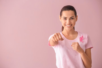 Poster - Beautiful woman with pink ribbon on color background. Breast cancer concept