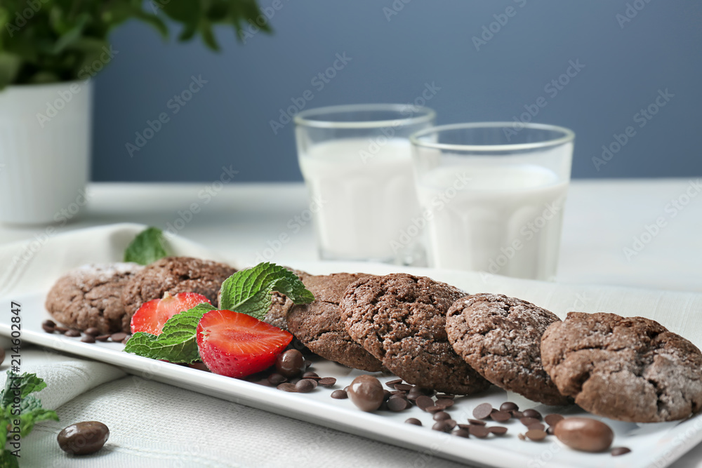 Plate with delicious chocolate cookies and fresh strawberry on table