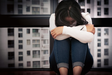 depressed women sitting near window, alone, sadness, emotional concept