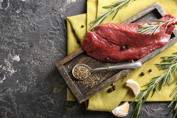 Fresh raw meat with spices and herbs on grey background