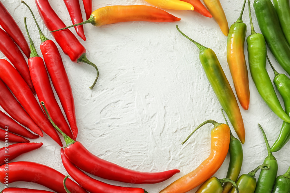 Frame made of fresh chili peppers on light background