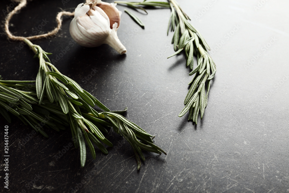 Fresh rosemary and garlic on dark background