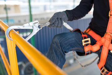 Construction worker wearing safety harness and safety line