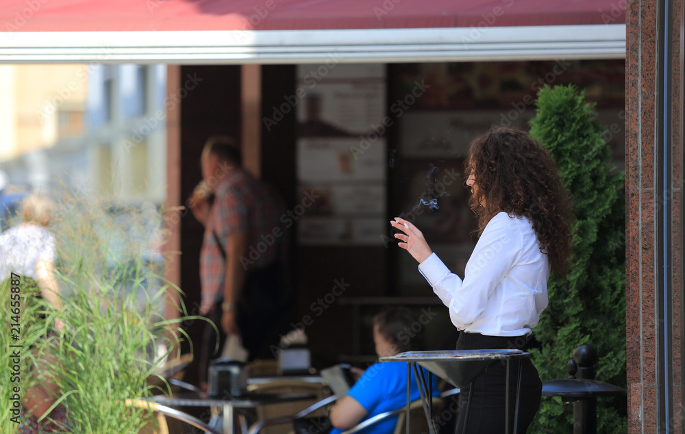 Kobieta, biznesmen pali papierosa przed restauracją. - obrazy, fototapety, plakaty 