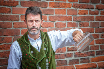 Wall Mural - bavarian man holding an empty beer mug