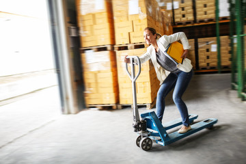 Customs female  manager drives forklift in the warehouse.Positive and fun business concept.