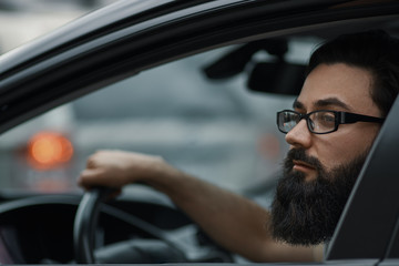 Close up portrait, serious man driving a car