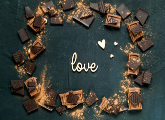 Wall Mural - chocolate frame and inscription  love on a dark background, copy space, close,