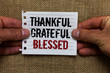 © Artur - Text sign showing Thankful Grateful Blessed. Conceptual photo Appreciation gratitude good mood attitude Man holding piece notebook paper jute background Communicating ideas.