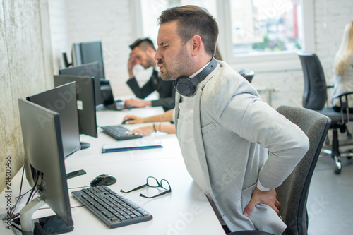 Cuadros en Lienzo Businessman suffering from backache in office